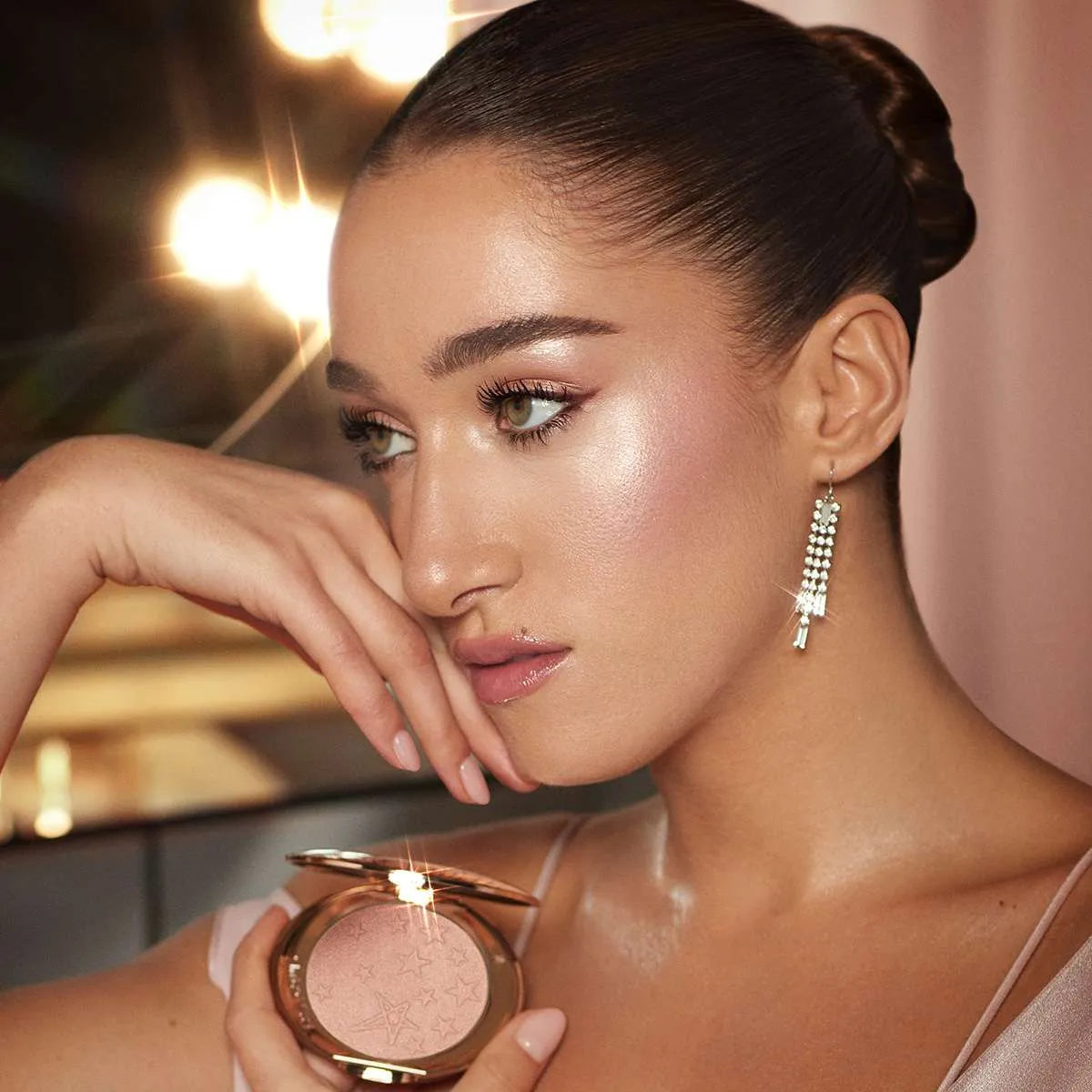 Charlotte Tilbury Hollywood Glow Glide highlighter in Pillow Talk Glow with model wearing glamorous makeup
