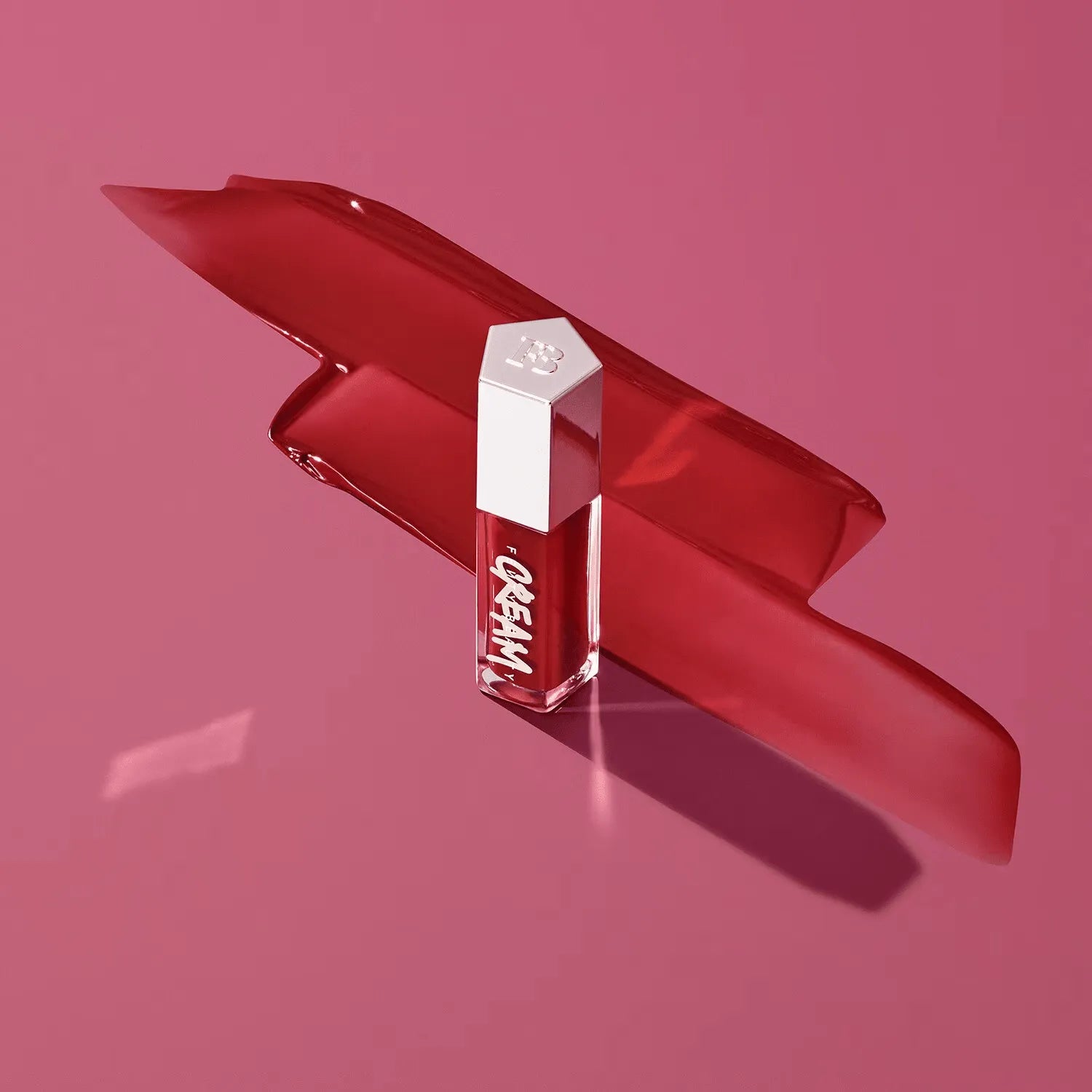 Close-up swatch of Fenty Beauty Gloss Bomb Cream in Fruit Snackz on skin, showing creamy berry red pigment