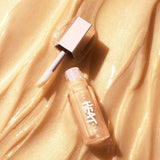 Swatch of Fenty Beauty Gloss Bomb Heat in Lemon Lava on skin, highlighting its warm golden-yellow shimmer and translucent finish.