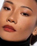 Fenty Beauty Gloss Bomb Heat model wearing Glass Slipper lip gloss with full face makeup