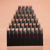 Flat lay of Huda Beauty FauxFilter Skin Finish stick foundation with brush and primer for routine