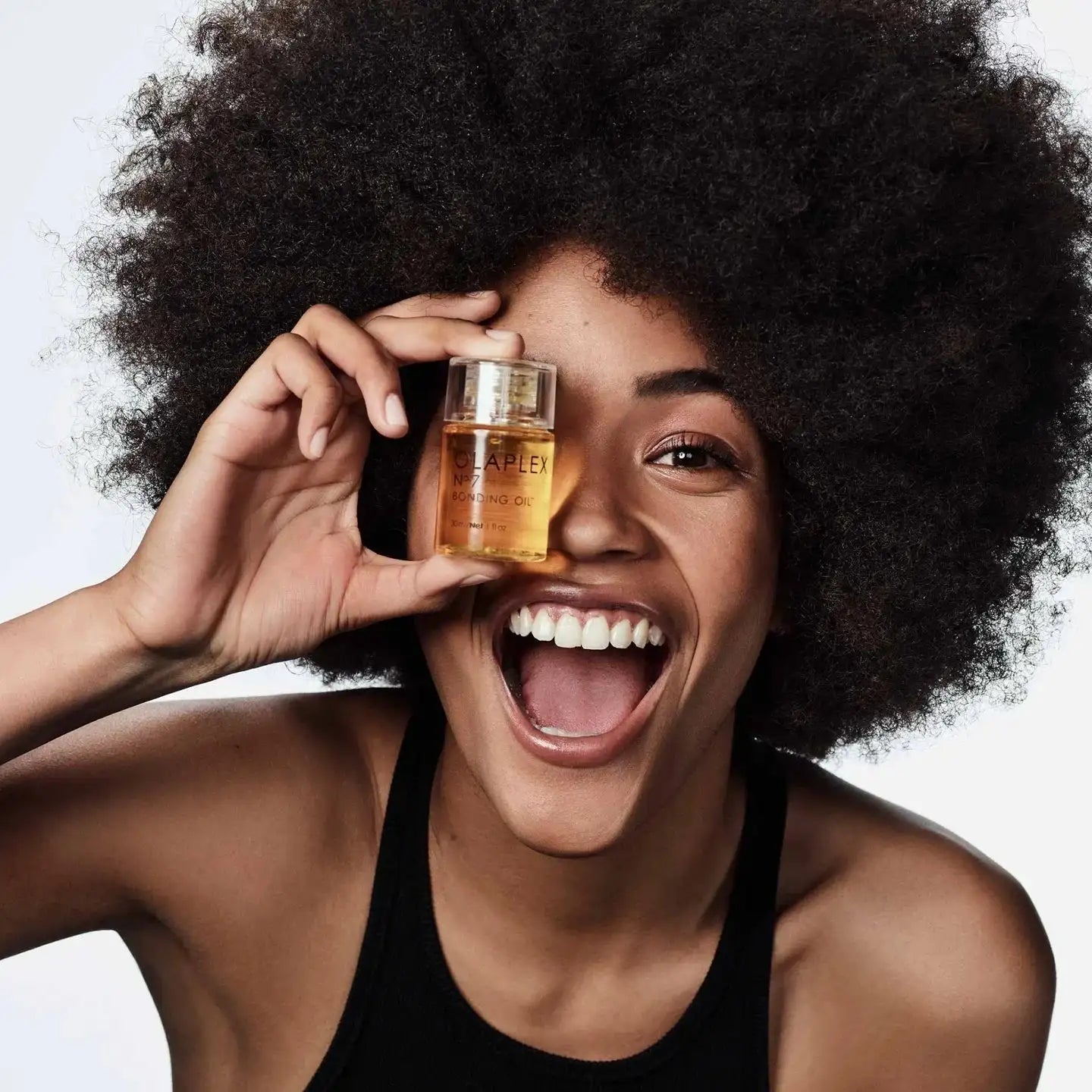 Olaplex Nº.7 Bonding Oil being applied to shiny hair