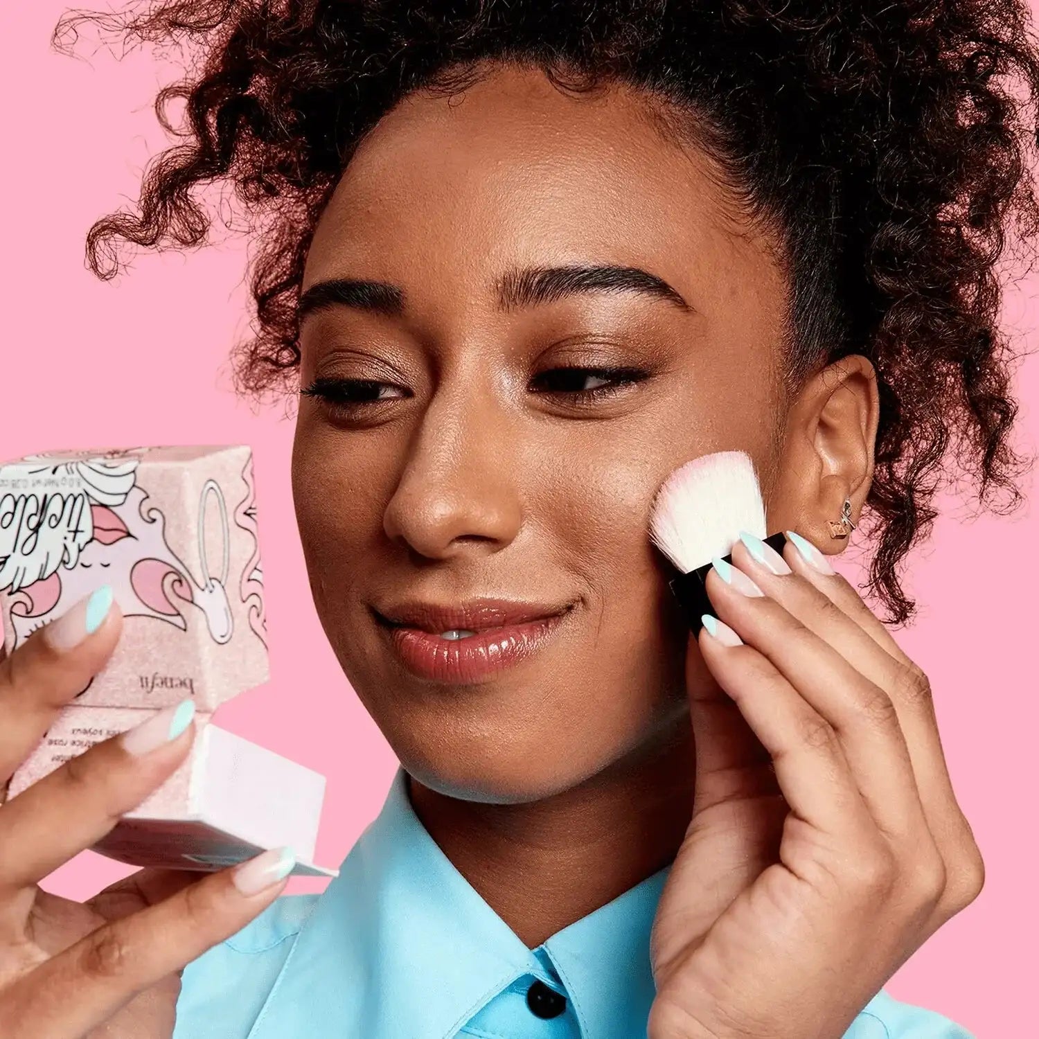 Close-up of Benefit Cookie Highlighter Powder swatch on skin, revealing the soft gold shimmer and smooth, blendable texture for a luminous finish.