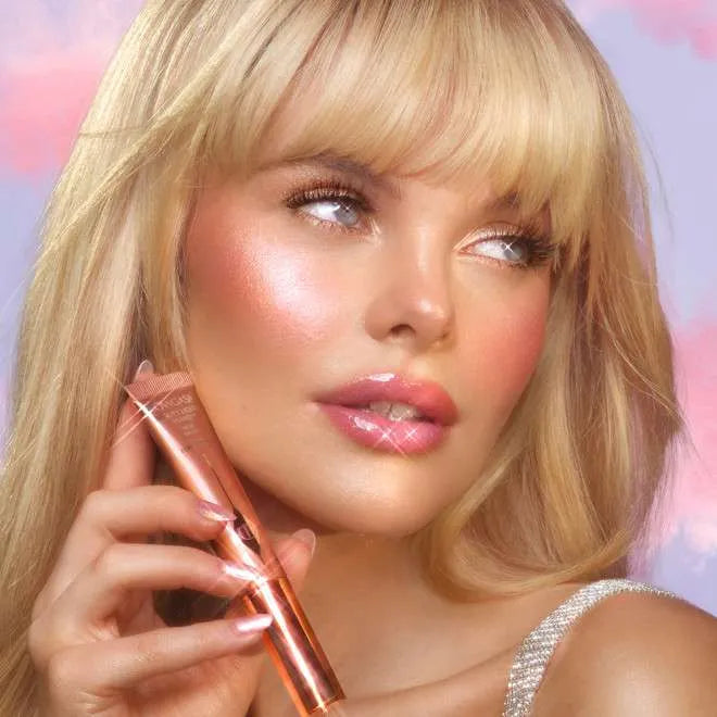 Model wearing Charlotte Tilbury Pinkgasm Beauty Light Wand as highlight blush on cheeks