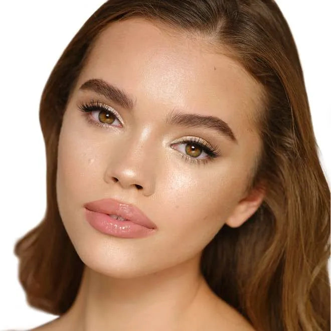 Woman wearing Charlotte Tilbury Moonlit Glow highlighter on cheeks for a luminous glow