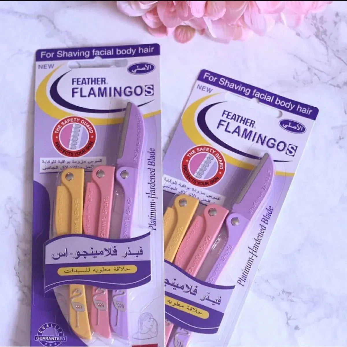 Close-up of Feather Flamingo Precision Razor blade showing safety guard and pink ergonomic handle