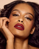 Model wearing Fenty Beauty Icon Velvet Liquid Lipstick The MVP on lips