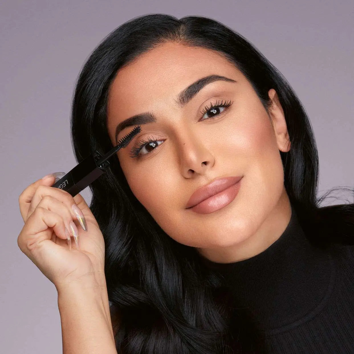 Model wearing Huda Beauty Legit Lashes mascara with voluminous eyelashes