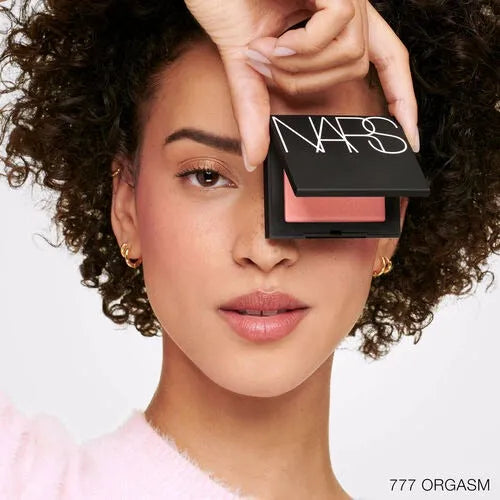 Model wearing NARS Orgasm blush on cheeks - natural glowy look