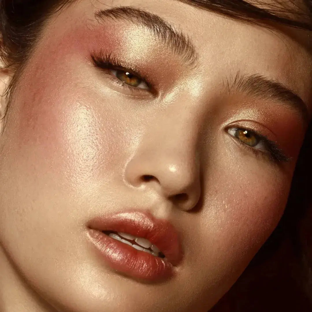 Swatches of the four shades from the Natasha Denona Bloom Face Glow Palette applied on different skin tones, highlighting the radiant finish and color payoff of the cream blush, glow cream, duo chrome, and metallic highlighter.