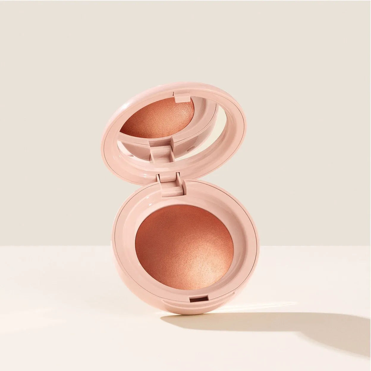 Close-up of Rare Beauty highlighter Reveal on skin demonstrating silky texture and radiance