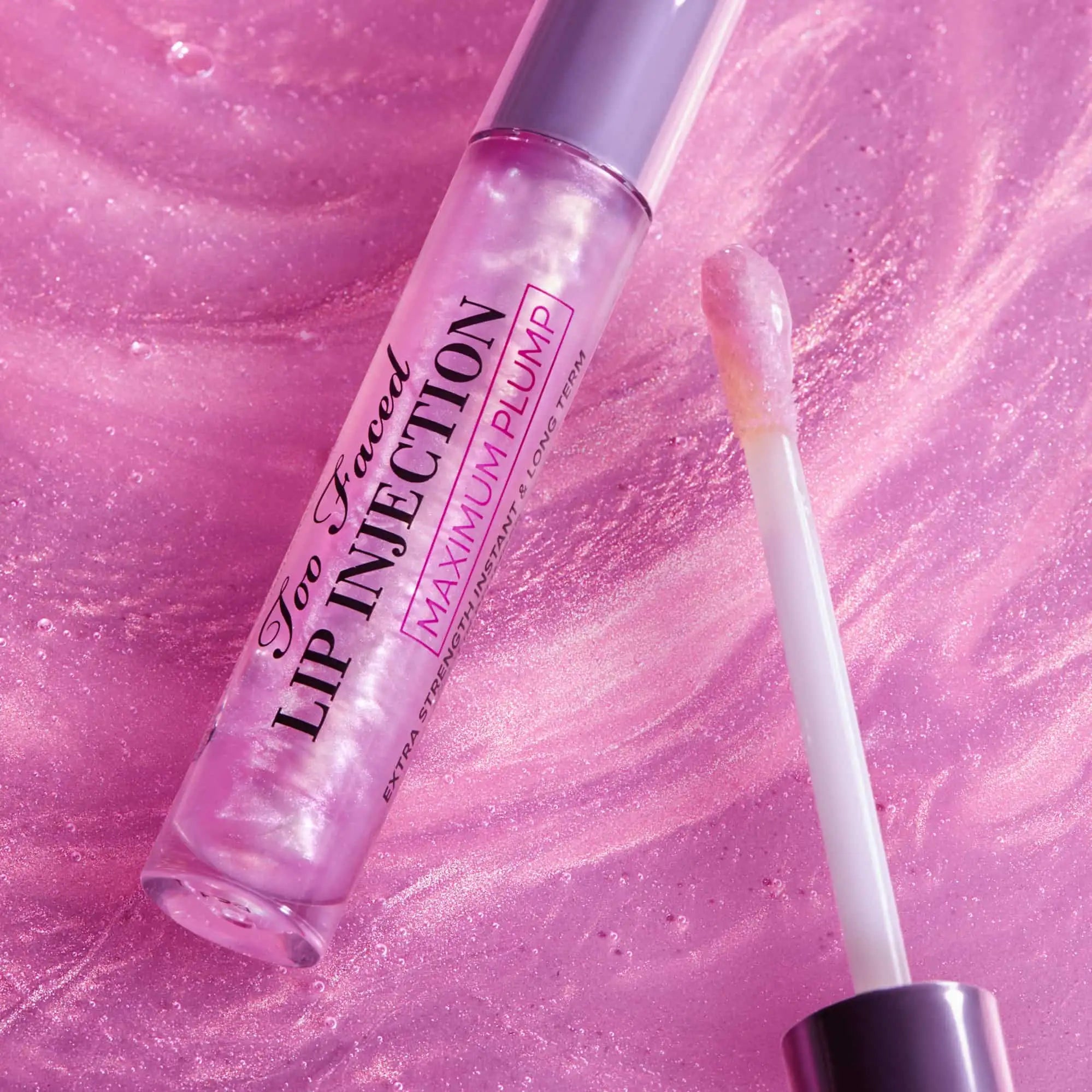 Too Faced Lip Injection Maximum Plump lip gloss bottle and applicator on white background